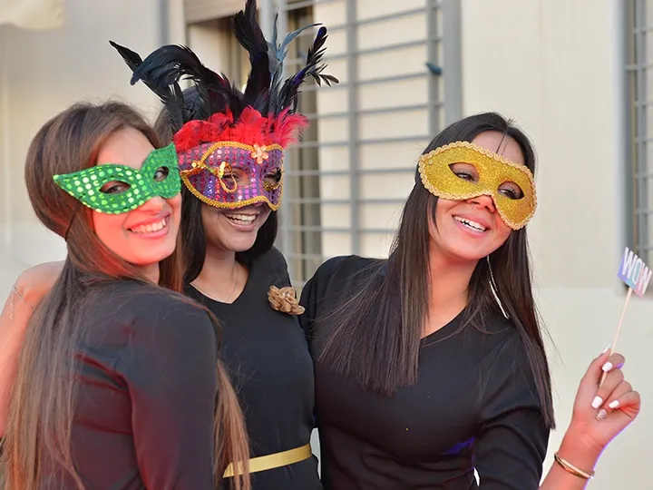 Trois amies masquées sourient, serrées les unes contre les autres