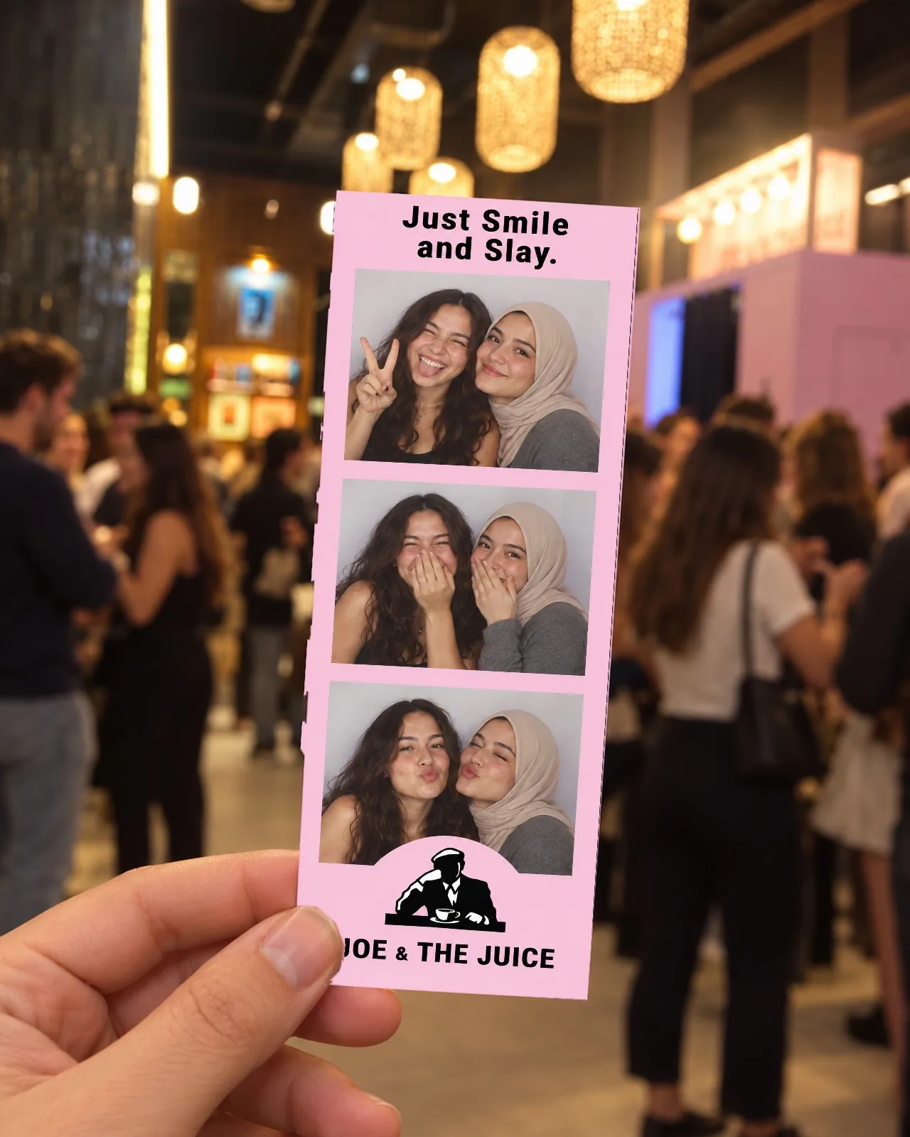Une main lève une bandelette « Just Smile and Slay » face à l’objectif, au milieu de la foule de la soirée d’ouverture
