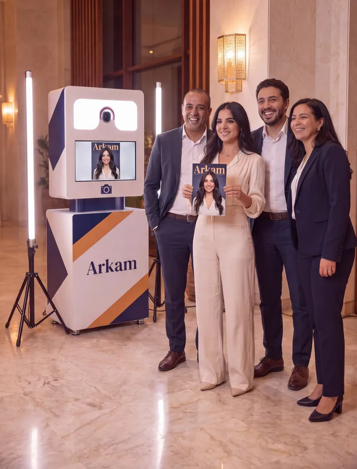 Réception d’entreprise dans un hôtel : quatre collègues posent devant le photobooth, l’une montre la couverture de magazine