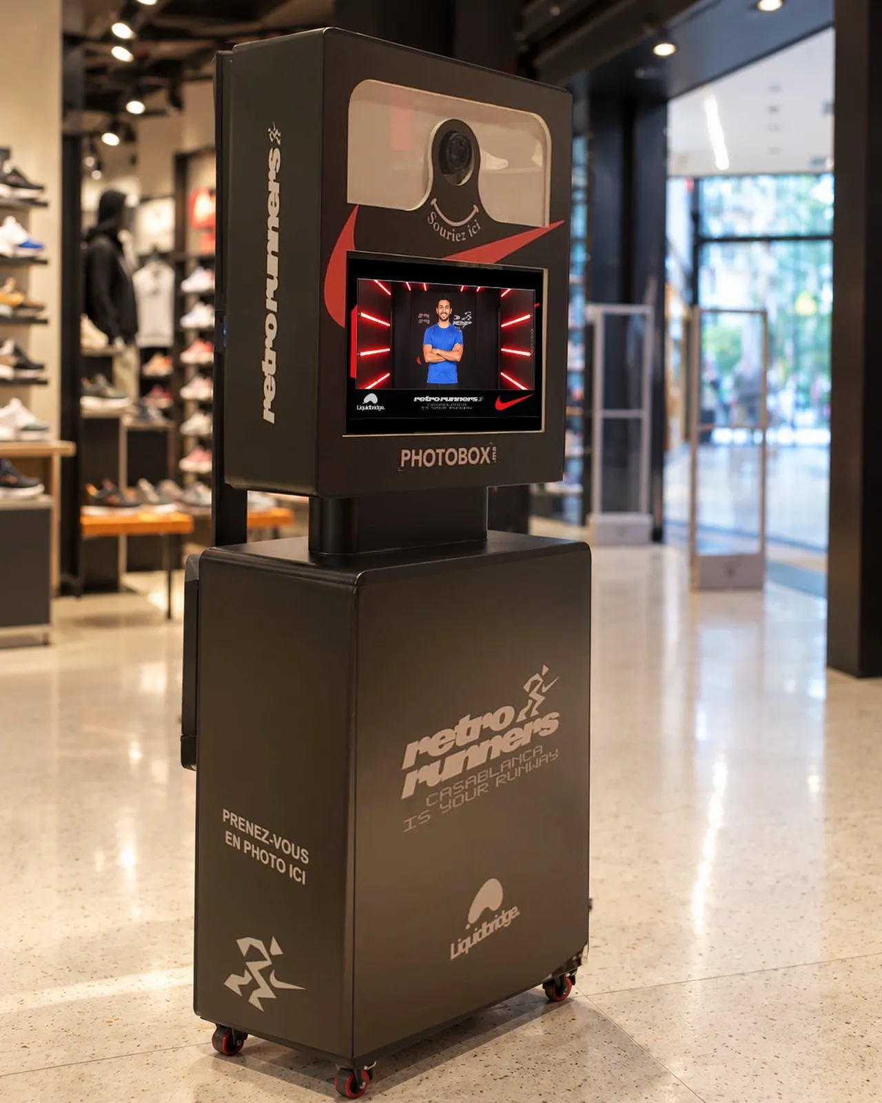 L’écran de la borne Retro Runners affiche le portrait d’un client dans le tunnel, sous l’objectif « Souriez ici »