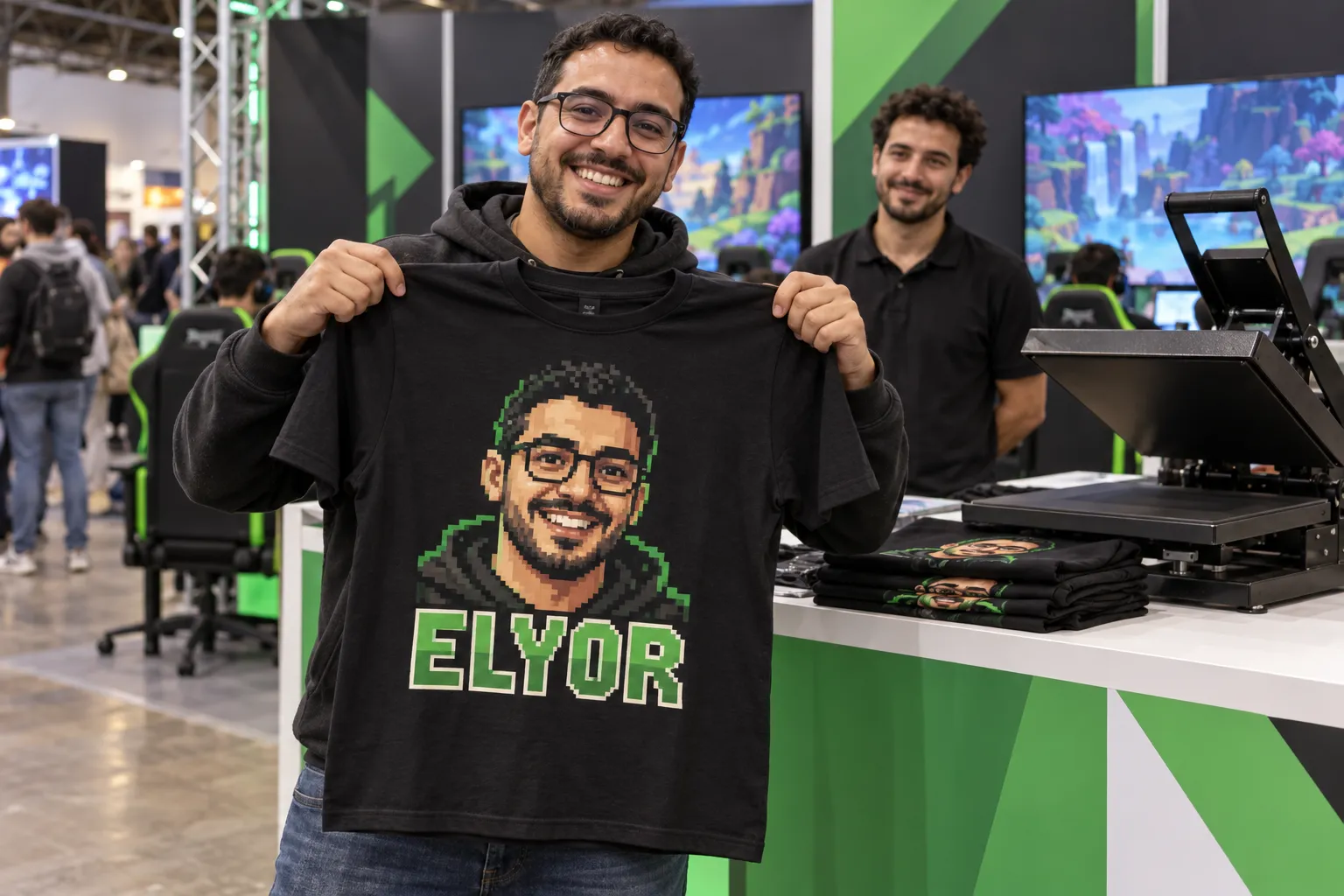 Un joueur présente le tee-shirt pressé sur le stand, avec son avatar en pixel art et le nom Elyor