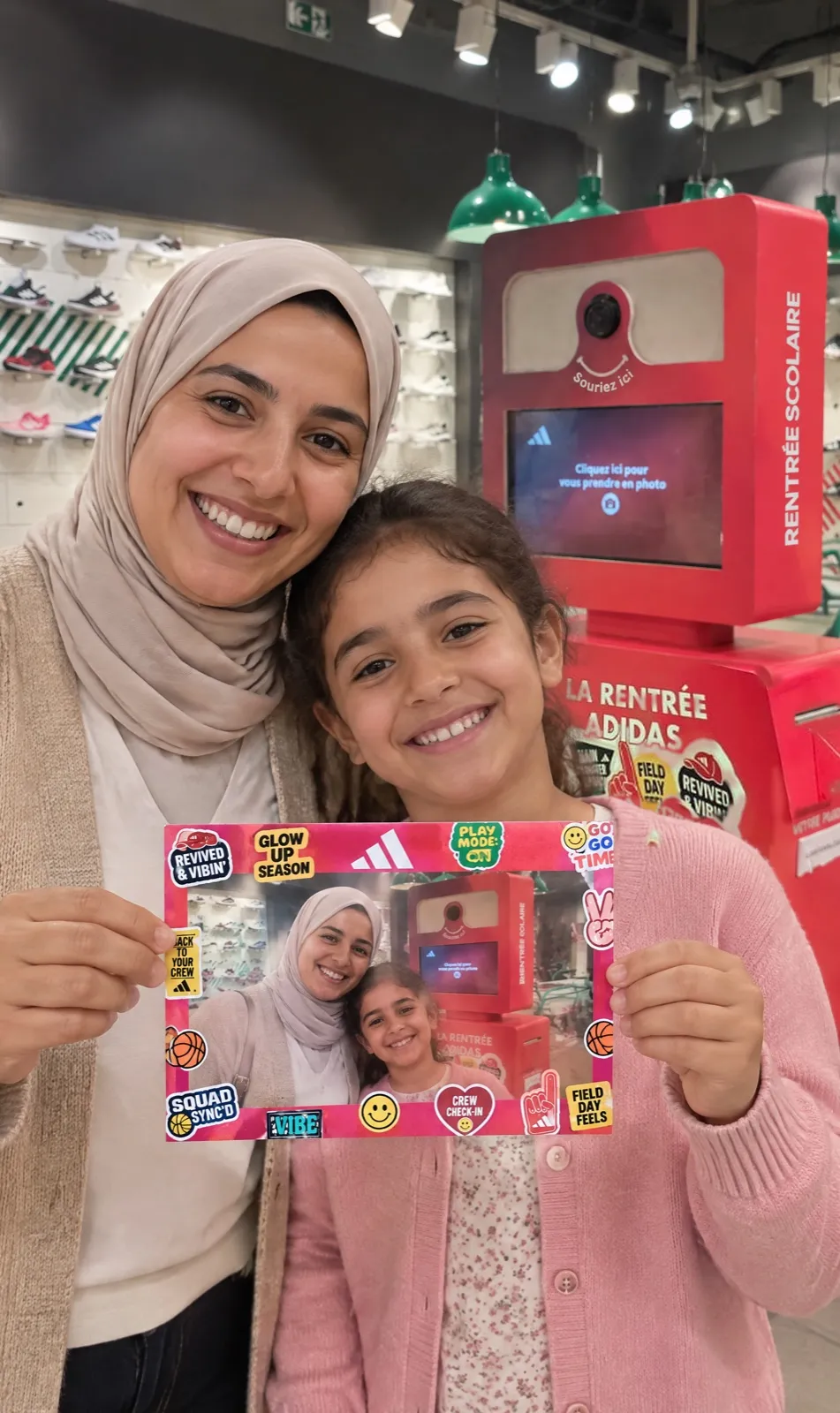 Une mère et sa fille présentent en riant leur carte collector, imprimée à leur portrait