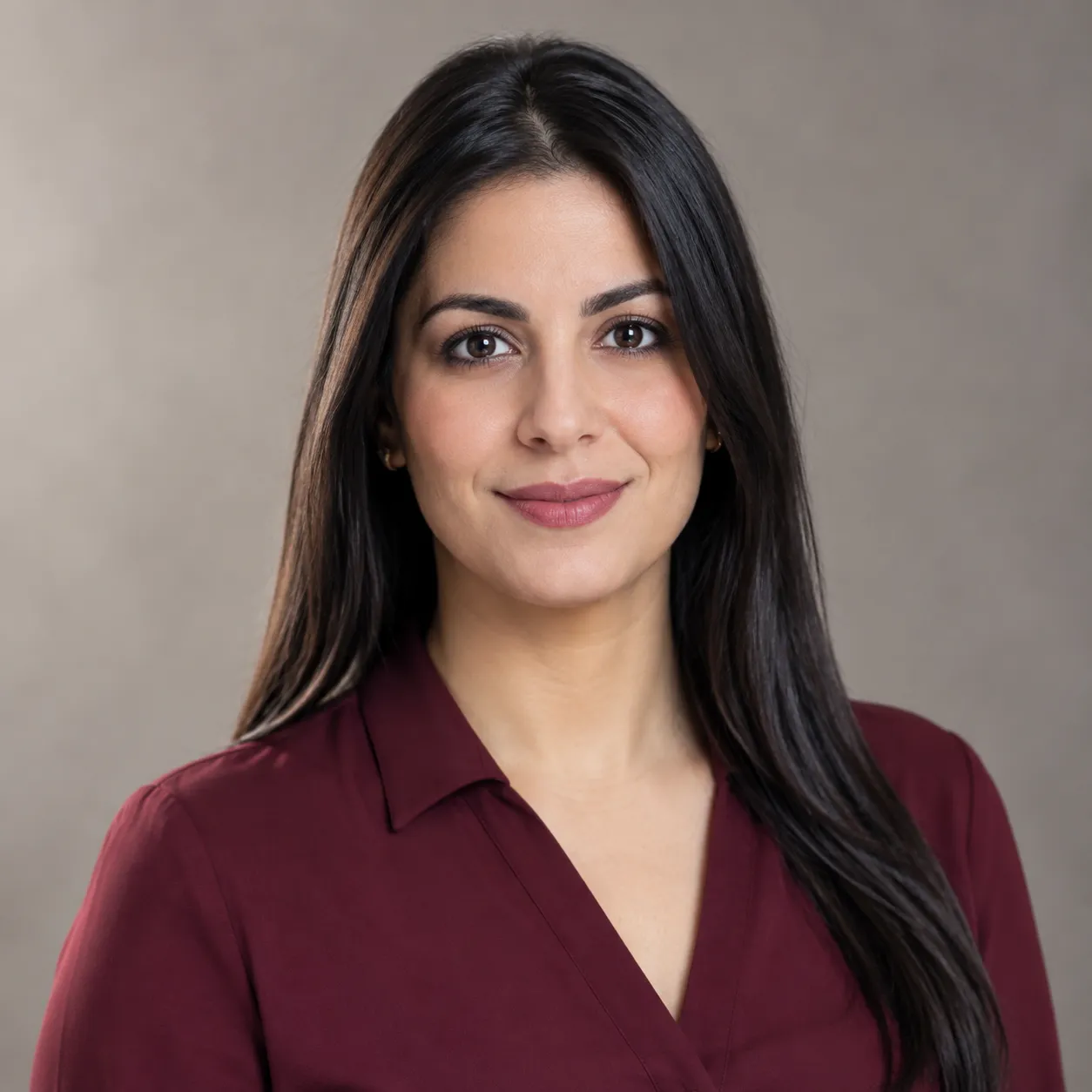 Portrait d’une femme en blouse bordeaux, sur fond neutre