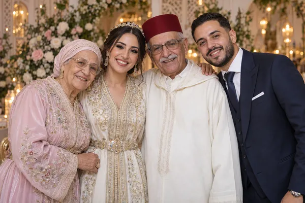 The wedding couple and their grandparents smile together