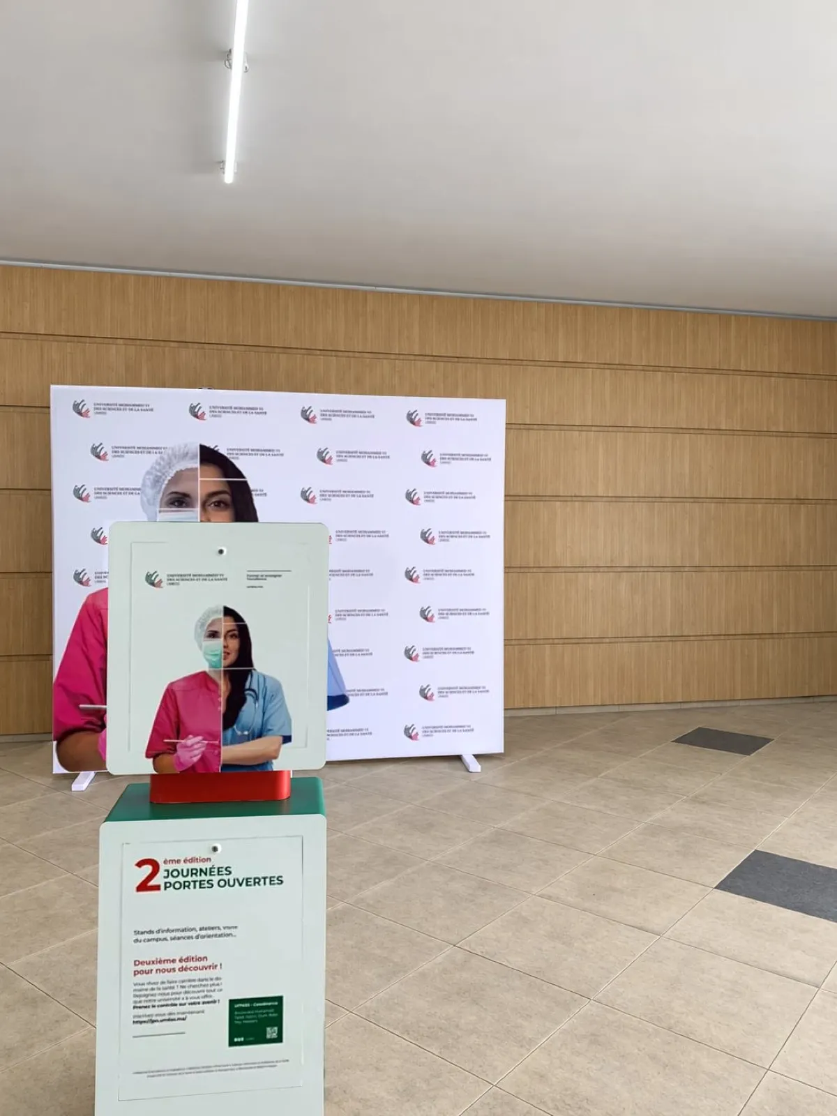 La Selfie Box UM6SS vue de dos, habillée de l’affiche des portes ouvertes, l’écran tourné vers le photocall de l’université avant l’ouverture