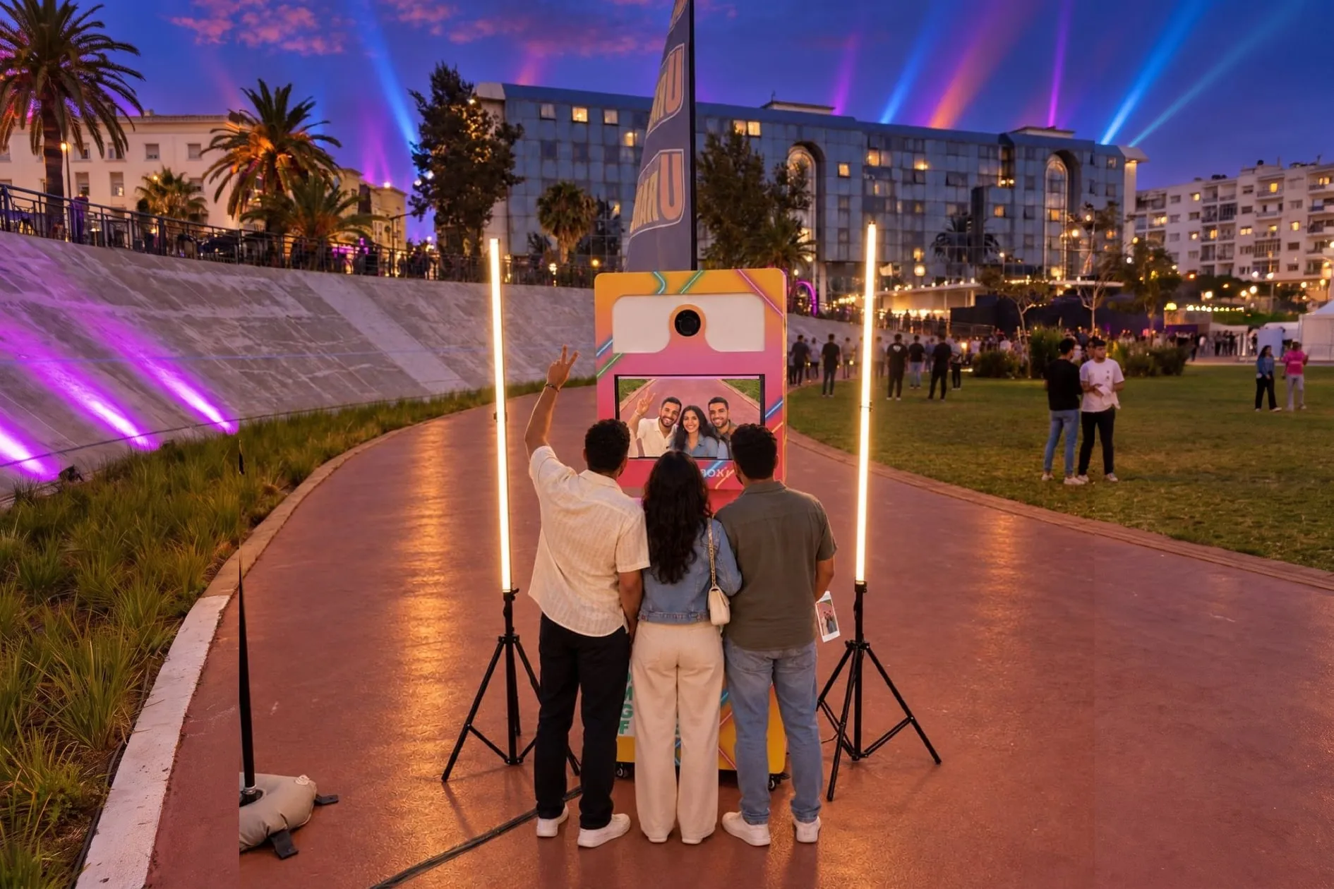 Le soir du festival, trois amis posent devant la Selfie Box U Radio, entre ses deux tubes lumineux, sur la piste du Vélodrome de Casablanca